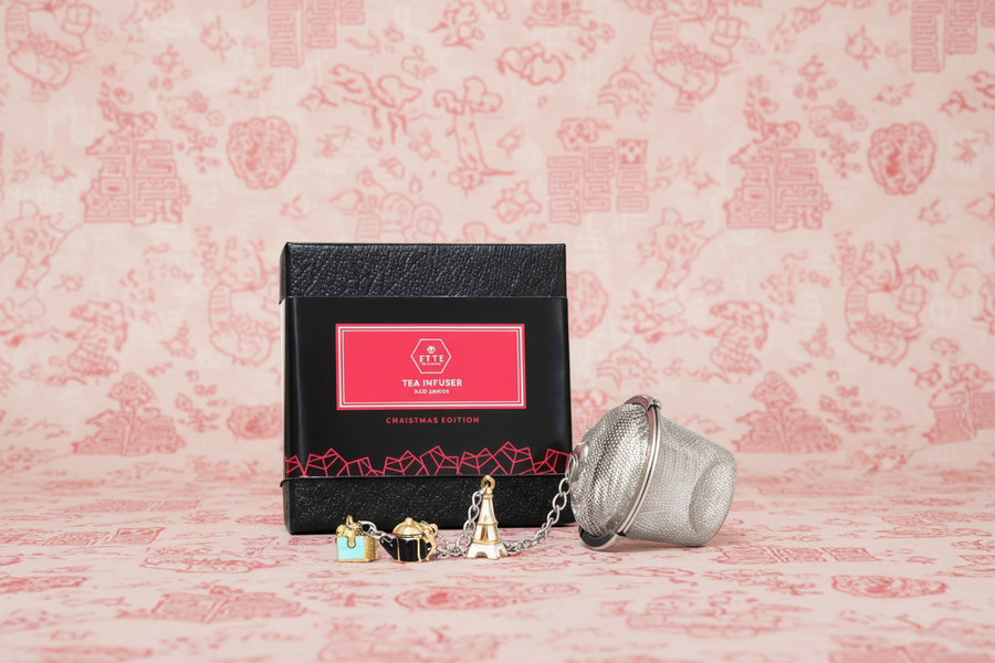 Tea infuser and packaging on a pink floral background