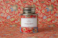 Tea canister with colorful design and label on a wooden surface