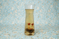 Clear glass vase with floral tea on a floral-patterned background
