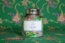 Decorative tea canister with floral design on a matching patterned background