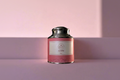 Pink tea canister with silver lid on a pink background