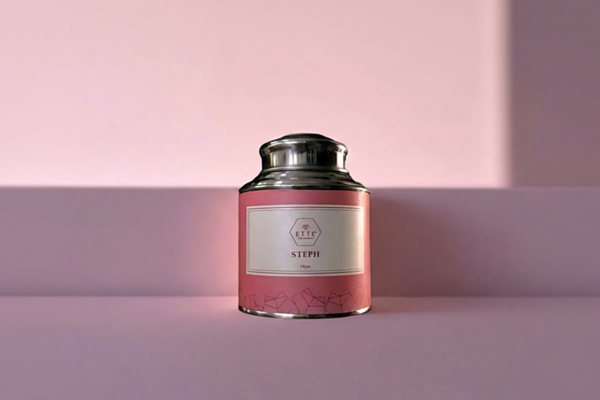 Pink tea canister with silver lid on a pink background
