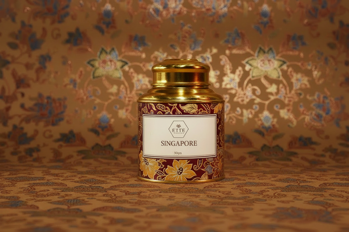 Decorative tea canister with 'SINGAPORE' branding on a patterned background