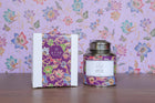 Decorative tea canister and packaging with 'ETTE' branding on a wooden surface.