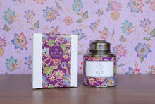 Decorative tea canister and packaging with 'ETTE' branding on a wooden surface.