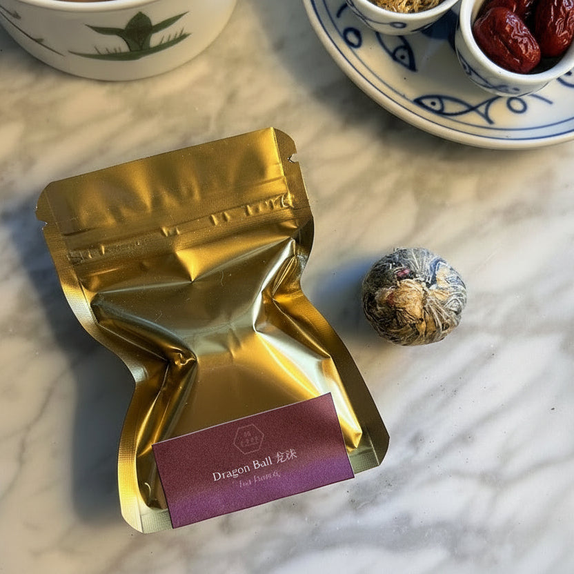 Gold tea package with a purple label on a marble surface